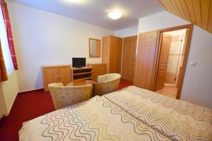 a bedroom with a bed and a desk with a computer at Chata Zahálka Ramzová in Ostružná