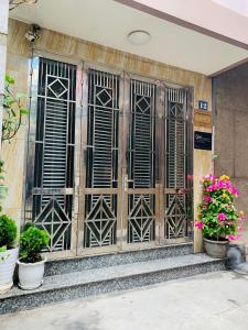 an entrance to a building with wooden doors and potted plants at GM Homestay in Hai Phong