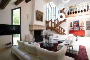 ein Wohnzimmer mit einer weißen Couch und einem Kamin in der Unterkunft Villa piscine/jacuzzi aux portes de Paris. in Lamorlaye