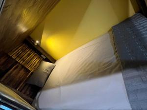 Lapis Restaurant and Hostel في Vũ Lâm: سرير في غرفة بجدار اصفر