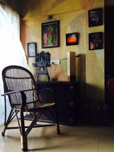 a chair sitting next to a dresser in a room at Majo House in Cherai Beach