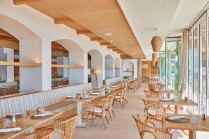 una fila di tavoli e sedie in un ristorante di Universal Hotel Aquamarin a Sant Elm