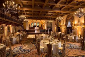 a banquet hall with tables and chairs and chandeliers at The Mission Inn Hotel and Spa in Riverside +96 photos