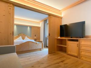 Habitación con una puerta corredera de cristal que conduce a un dormitorio. en Hotel Gertraud en Solda