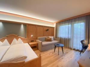 una camera d'albergo con letto e divano di Hotel Gertraud a Solda