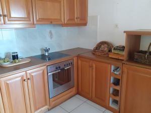 a kitchen with wooden cabinets and a stove at Olivenhainhaus / Eleonas in Asopós