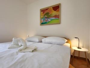 a bedroom with a white bed with a picture on the wall at Holiday Home Belka with Terrace&BBQ in Tolmin
