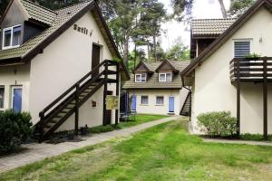 a row of white houses with a path between them at O.W.Sztil in Pobierowo