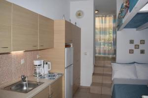uma pequena cozinha com um lavatório e uma cama em Seaside Nicola's Studio em Matala