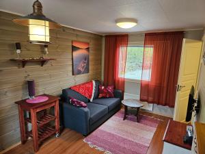 ein Wohnzimmer mit einem Sofa und einem Tisch in der Unterkunft Holiday Village Nuorgamin Lomakeskus in Nuorgam