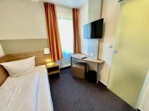 a hotel room with a bed and a desk with a television at Gasthof Krancher in Rüdesheim am Rhein