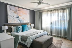 a bedroom with a bed and a ceiling fan at Kingsbeach Cottages in Port Elizabeth