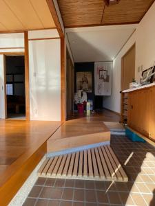 uma sala de estar com piso em madeira e uma mesa em Boss'sHouse犬ok天然温泉あり em Kirishima