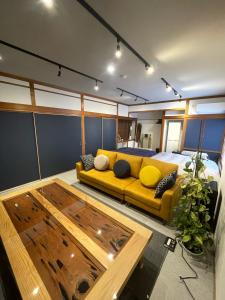 uma sala de estar com um sofá amarelo e uma cama em Boss'sHouse犬ok天然温泉あり em Kirishima