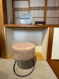 um banco sentado debaixo de uma prateleira numa sala em Boss'sHouse犬ok天然温泉あり em Kirishima