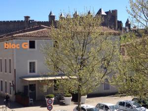 uma árvore num parque de estacionamento em frente a um edifício em B&B Bloc G em Carcassonne