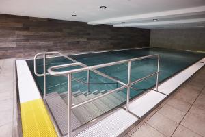 une piscine vide avec une balustrade métallique dans l'établissement Ferienwohnung Berglicht, Ambiente im Allgäu, à Fischen im Allgäu