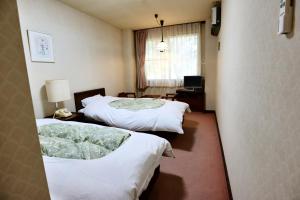 Postel nebo postele na pokoji v ubytování Hakuba Park Hotel