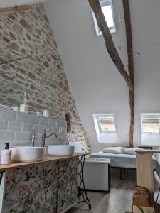 a bathroom with two sinks in front of a stone wall at Le Quatorze, au cœur de Najac in Najac