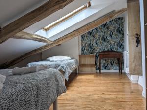 a bedroom with two beds and a wall mural at Le Quatorze, au cœur de Najac in Najac