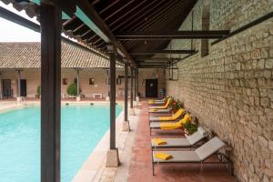 a row of lounge chairs next to a swimming pool at Parador de Chinchón in Chinchón