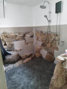 kamienna łazienka z prysznicem i kamienną ścianą w obiekcie RED PEARL BEACH RESORT w mieście Chaloklum