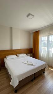 a bedroom with a large white bed with a window at KUZEY OTEL in Sinop