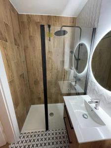 W łazience znajduje się prysznic, umywalka i lustro. w obiekcie Liwia Park Green House w mieście Niechorze