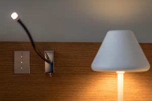 une lampe blanche avec un câble branché sur une sortie dans l'établissement Yndo Hôtel, à Bordeaux