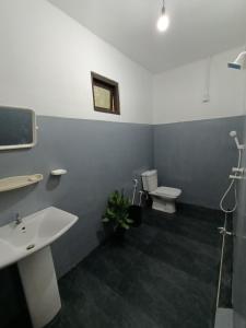 een badkamer met een wastafel en een toilet bij Ocean Bliss in Pottuvil