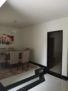 a dining room with a table and chairs and a mirror at Casa Piratininga Niterói Rj in Niterói