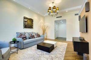 a living room with a blue couch and a tv at Stunning sew view apartment in JBR in Dubai