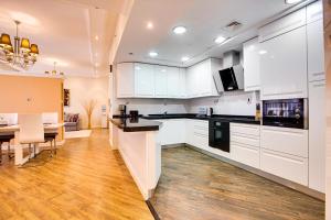 a kitchen with white cabinets and a dining room at Stunning sew view apartment in JBR in Dubai