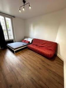 un gran sofá rojo sentado en una habitación en Appartement GARE Juvisy*ORLY AIRPORT*Paris en Juvisy-sur-Orge