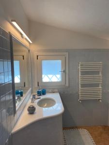 ein Badezimmer mit Waschbecken und Spiegel in der Unterkunft Villa Belinda in Santa Margherita di Pula