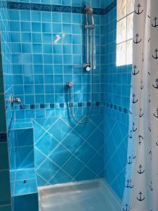 ein blau gefliestes Bad mit einer Dusche und einer Badewanne in der Unterkunft Villa Belinda in Santa Margherita di Pula + 39 Fotos