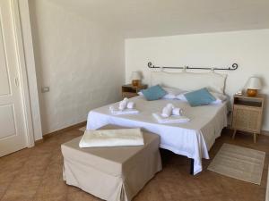 a bedroom with two beds with blue pillows at Villa Belinda in Santa Margherita di Pula