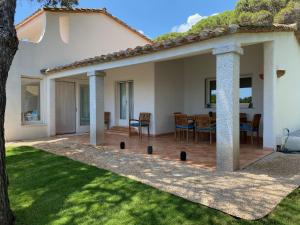 eine Terrasse mit Tisch und Stühlen in einem Hof in der Unterkunft Villa Belinda in Santa Margherita di Pula