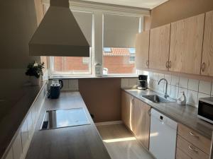 a small kitchen with a sink and a window at Lille Vedelsborg in Vejle