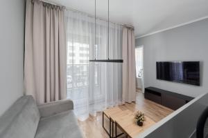 a living room with a couch and a large window at Gwiaździsta Apartment by the Sky Tower in Wrocław by Renters in Wrocław