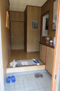 a room with a kitchen with shoes on the floor at Guest house Matsuo 