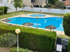una grande piscina con ombrelloni in un cortile di MyChoice Alegria by Bossh! Apartments a Rota