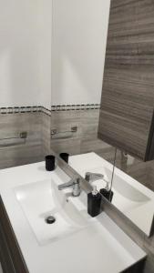 uma casa de banho com um lavatório branco e um espelho. em La Rosa dei Venti em Teulada