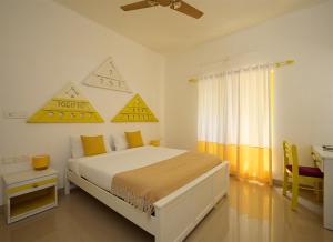 a bedroom with a bed and a desk in it at Seclude by the Lake, Alleppey in Alleppey