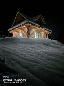 a small wooden house with snow on the ground at Domek u Sołtyska in Rajcza