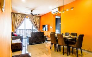 una sala da pranzo con pareti arancioni e tavolo e sedie di Platz @ KL North Setapak by Airhost a Kuala Lumpur