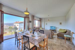 ein Wohnzimmer mit einem Tisch, Stühlen und einem Sofa in der Unterkunft Residenza Il Parco Family Retreat in Ispra