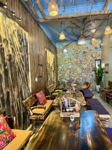 Lapis Restaurant and Hostel في Vũ Lâm: مطعم فيه كنب وطاولات في الغرفة