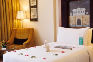 um quarto de hotel com uma cama e uma cadeira em Le Meridien Jaipur Resort & Spa em Jaipur