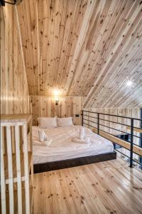 a bed in a room with a wooden ceiling at Norway Cabins Sinaia Romantic Nordic Escape and Fire Pit in Sinaia